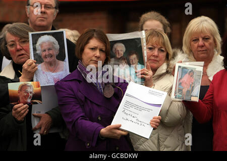 Verwandte von Patienten, die an dem Bericht beteiligt sind, halten Bilder ihrer Angehörigen vor dem Hotel in Moat House in der Nähe von Stafford, nachdem Robert Francis QC seinen Bericht über Fehler im Stafford Hospital abgegeben hat. Stockfoto