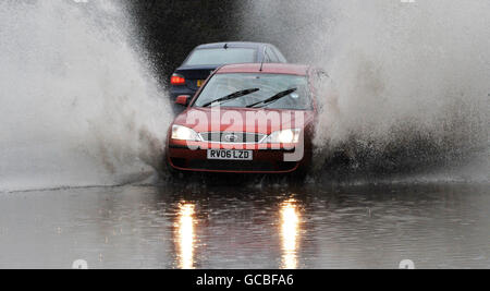 Ein Auto fährt durch tiefes Wasser, nachdem starke Regenfälle lokale Überschwemmungen in Essex verursacht haben. Stockfoto