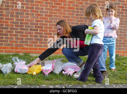 Corrine Ash-Hill und die Töchter Alyssa, 5 und Gracie, 3 (Mitte), hinterlassen Blumen in der Nähe des Hauses von Stephanie Bellinger, 24, deren Körper am Samstag neben dem ihrer kleinen Tochter, der acht Monate alten Lily, in Totton bei Southampton gefunden wurde. Stockfoto