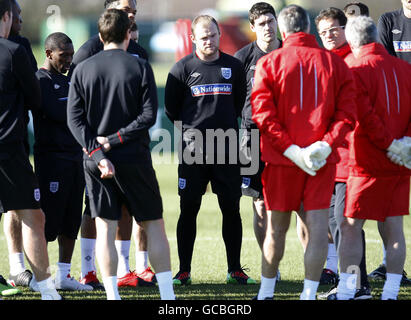 Der englische Wayne Rooney (Schwerpunkt Mitte) hört Manager Fabio Capello (dritter rechts) während der Trainingseinheit in London Colney, Watford. Stockfoto