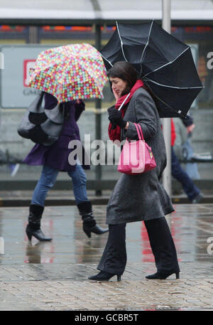 Der Regenschirm einer Frau wird von innen nach außen geblasen, als starker Wind und Regen das Stadtzentrum von Manchester treffen. Stockfoto