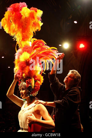 Costumier Annie Galbraith (rechts) passt ein Kopfkleid von Carmen Miranda an, das ursprünglich vom weiblichen Imitator Danny La Rue getragen wurde und Teil einer Sammlung seiner 90 Kostüme und Kleider ist, die am Freitag, dem 12. März, in der Brick Lane Music Hall im Osten Londons bei einer Auktion angeboten werden. Stockfoto