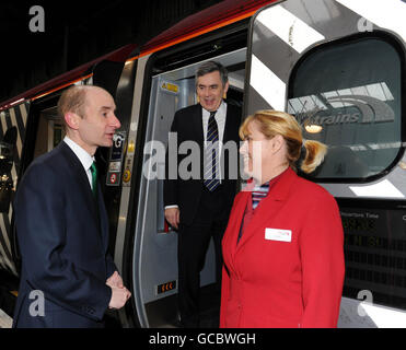 Verkehrssekretär Lord Adonis (links) und Premierminister Gordon Brown (Mitte) sprechen mit einem Mitarbeiter von Virgin Trains (Name nicht bekannt) am Bahnhof Euston, London. Stockfoto