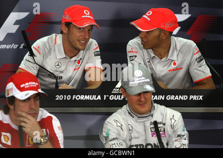 McLaren-Fahrer Jenson Button (oben links) und Lewis Hamilton unterhalten sich während der Pressekonferenz während eines Paddock-Tages auf dem Bahrain International Circuit in Sakhir, Bahrain. Stockfoto