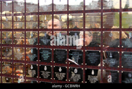 Mitglieder der Öffentlichkeit sehen die Basra Memorial Wall im National Memorial Arboretum in der Nähe von Alrewas in Staffordshire, vor einem Dienst, um die Mauer wieder zu widmen, nachdem sie aus Basra, Irak, verlegt wurde. Stockfoto