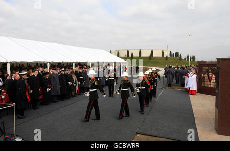 Familienmitglieder von gefallenen Dienstkräften und Würdenträgern stehen an der Basra Memorial Wall im National Memorial Arboretum in der Nähe von Alrewas in Staffordshire, während eines Dienstes zur Wiederweihe der Mauer, nachdem sie aus Basra, Irak, verlegt wurde. Stockfoto