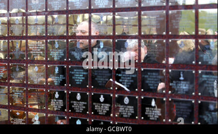 Mitglieder der Öffentlichkeit sehen die Basra Memorial Wall im National Memorial Arboretum in der Nähe von Alrewas in Staffordshire, vor einem Dienst, um die Mauer wieder zu widmen, nachdem sie aus Basra, Irak, verlegt wurde. Stockfoto