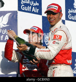 McLaren Lewis Hamilton (rechts) feiert seinen dritten Platz mit dem Sieger Fernando Alonso beim Grand Prix der Gulf Air Bahrain auf dem Bahrain International Circuit in Sakhir, Bahrain. Stockfoto