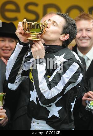 Pferderennen - 2010 Cheltenham Festival - Tag Vier. Der Jockey Paddy Brennan küsst die Gold Cup Trophy, nachdem er sie im kaiserlichen Kommandanten gewonnen hat. Stockfoto