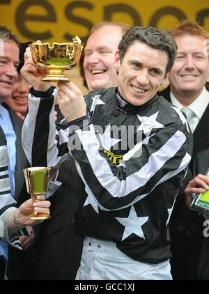 Jockey Paddy Brennan erhält die Gold Cup Trophy, nachdem er den totesport Cheltenham Gold Cup im Imperial Commander gewonnen hat. Stockfoto