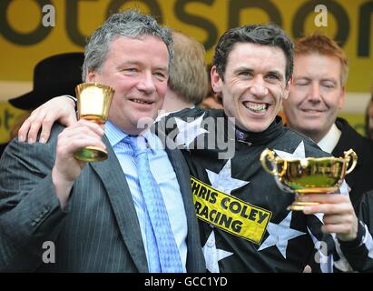 Jockey Paddy Brennan (rechts) und Pferdetrainer Nigel Twiston-Davies (links) mit ihren Trophäen nach dem Sieg im totesport Cheltenham Gold Cup. Stockfoto