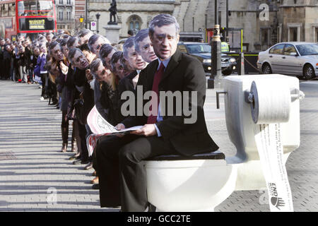 Mehr als hundert Menschen mit Gordon Brown-Masken standen im Old Palace Yard, Westminster, London, vor einer riesigen Toilette zum Weltwassertag der Vereinten Nationen, um die Kampagne „Ende der Wasserarmut“ zu unterstützen, die den Premierminister dazu aufruft, die globale Sanitärkrise anzugehen. Stockfoto