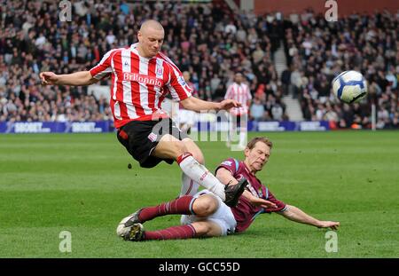 Jonathan Spector von West Ham United bekämpft Andy Wilkinson von Stoke City (Links) Stockfoto