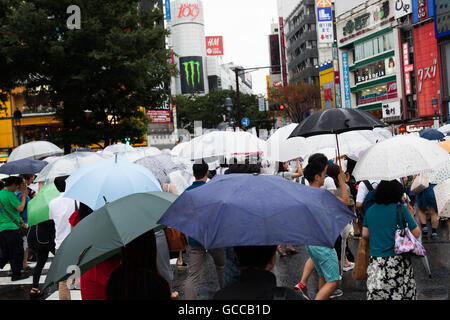 Tokio, Japan. 9. Juli 2016. Fußgänger halten Sonnenschirme im Regen im Gerangel der Shibuya Kreuzung am 9. Juli 2016, Tokio, Japan. Die jährliche Regenzeit oder Tsuyu in Japan läuft von Juni bis Mitte Juli. Bildnachweis: Rodrigo Reyes Marin/AFLO/Alamy Live-Nachrichten Stockfoto