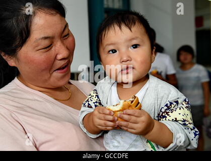 Putian, der chinesischen Provinz Fujian. 9. Juli 2016. Eine Mutter mit ihrem Kind hat eine Pause in einer Notunterkunft in einer Grundschule von Licheng Bezirk in Putian, Südosten der chinesischen Provinz Fujian, 9. Juli 2016. Nepartak, der erste Taifun des Jahres brachten Starkregen in der Stadt. Mehr als 59.000 Mitarbeiter wurden Sicherheit dorthin verlegt. Bildnachweis: Zhang Guojun/Xinhua/Alamy Live-Nachrichten Stockfoto