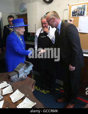 Königin Elizabeth II erfüllt die Kelpies Bildhauer Andy Scott in der Silberschmiede Werkstatt während eines Besuchs in Hamilton und Zoll Juweliere in Edinburgh mit dem Herzog von Edinburgh, wo sie betrachtet eine Anzeige von Artefakten und trafen sich Handwerker, darunter einige, die sind Teil der Queen Elizabeth Stipendium Trust gegründet, um vielversprechende junge Menschen ihre Fähigkeiten zu entwickeln, durch die Arbeit mit Meistern ihres Fachs zu ermöglichen. Stockfoto