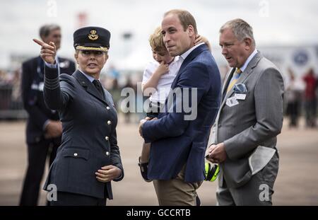 Prince George mit seinem Vater Herzog von Cambridge, Carol Vorderman, die der Luft-jüngstere Söhne-Botschafter ist und eine ehrenamtliche Gruppe Kapitän während eines Besuchs in der Royal International Air Tattoo an RAF Fairford - größte militärische Airshow der Welt erfüllen. Stockfoto