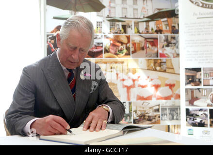 Der Prinz von Wales, in seiner Rolle als Präsident des PRIME Cymru, signiert ein Buch von seiner Aquarelle, das ist für einen guten Zweck versteigert werden, vor der Sitzung einige derjenigen, die Teilnahme an der Gründungsversammlung Llandovery Motorrad Wochenende und vor dem Ablegen der Flagge auf eine Parade von Fahrrädern durch die Stadt, während ein Visitto Llandovery, Wales. Stockfoto