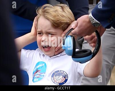 Hinweis alternative Ernte Prince George reagiert auf den Lärm während einer Fliege Vergangenheit durch die roten Pfeile während eines Besuchs in der Royal International Air Tattoo an RAF Fairford - größte militärische Airshow der Welt, mit seinen Eltern der Herzog und Herzogin von Cambridge. Stockfoto