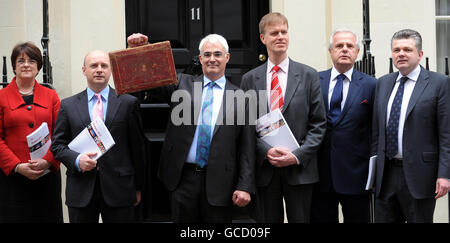 Kanzler Alistair Darling hält mit seinen Mitarbeitern des Finanzministeriums vor der Downing Street 11 in London seine rote Kiste hoch, bevor er zum Unterhaus geht, um die Haushaltspläne der Regierung bekannt zu geben. Stockfoto