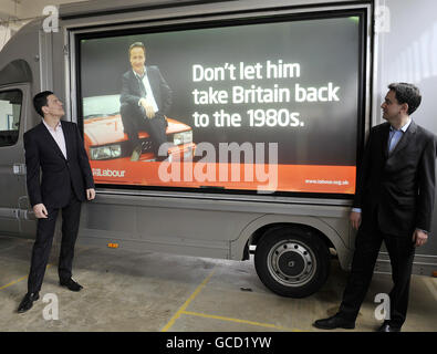 Außenminister David Miliband (links) und sein Bruder Ed Miliband, Staatssekretär für Energie und Klimawandel, während des Starts der jüngsten Plakatkampagne ihrer Partei in Basildon, Essex, mit der Darstellung des Vorsitzenden der Konservativen Partei David Cameron als Fernsehdetektiv Gene Hunt, Entwickelt, um Erinnerungen an soziale Unruhen und Jugendarbeitslosigkeit der 1980er Jahre wiederzubeleben. Stockfoto