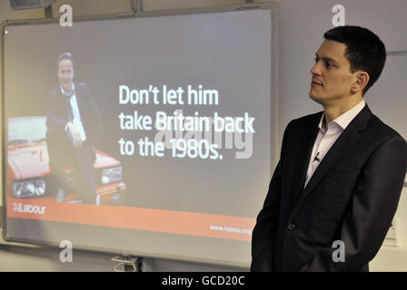 Außenminister David Miliband während des Starts der jüngsten Plakatkampagne seiner Partei in Basildon, Essex, in der der Vorsitzende der Konservativen Partei David Cameron als Fernsehdetektiv Gene Hunt dargestellt wird, der die Erinnerungen an die sozialen Unruhen und die Jugendarbeitslosigkeit der 1980er Jahre wiederbeleben soll. Stockfoto