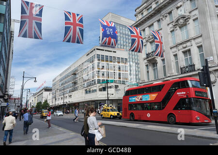 London Shopper Straßenszene auf der Oxford Street mit Union Jack-Flaggen Stockfoto