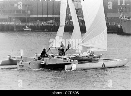 AJAX-NEWS-FOTOS. 4. MAI 1974. PORTSMOUTH, ENGLAND. -BANK-MANAGER SAILOR - BRIAN COOKE UND SEINE CREW ERIC JENSEN DREIFACH PFEILRICHTUNG TRIMARAN SEGELN.  FOTO: JONATHAN EASTLAND/AJAX REF: TRIPLE ARROW 1974 1 HINWEIS ** 20. FEBRUAR 1976. EINSAMER SEEMANN GEFÜRCHTET ERTRUNKEN - 54 JAHRE ALTEN BANK-MANAGER BRIAN COOKE VON PARKSTONE, DORSET BEFÜRCHTET WURDE ERTRUNKEN HEUTE NACH SEINEM TRIMARAN DREIFACHPFEIL NACH GEKENTERTEN 450 MEILEN WESTLICH VON KANARISCHEN INSELN VON EINEM NORWEGISCHEN MASSENGUTFRACHTER GEFUNDEN WURDE.  COOKE, EIN VETERAN OCEAN RACER, SATZ SEGEL AUS PLYMOUTH, ENGLAND AM 7. DEZEMBER/75 AUF SEINEM ZWEITEN VERSUCH, DIE ATLANTISCHEN GESCHWINDIGKEIT UND DISTANZ STUDIE SCHLAGEN Stockfoto