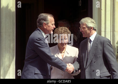 Premierminister John Major schüttelt die Hände mit dem ehemaligen amerikanischen Präsidenten George Bush auf den Stufen der Downing Street Nummer 10, während Norma Major aufwacht. Stockfoto