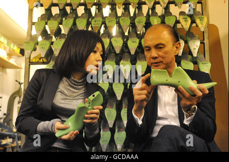 Schuhdesigner Jimmy Choo gibt dem Studenten Nikki Lin in seiner Londoner Werkstatt eine Lektion. Stockfoto