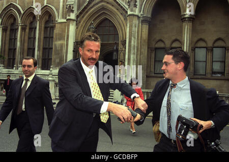 DER EHEMALIGE ENGLAND CRICKET CAPTAIN HILFT DEM SPIEGELFOTOGRAFEN JAMES VELLACOTT, NACHDEM ER VOR DEM HIGH COURT UMGESTÜRZT IST. BOTHAM WAR VOR GERICHT WÄHREND DER VERLEUMDUNGSKLAGE GEGEN IMRAN KHAN. Stockfoto