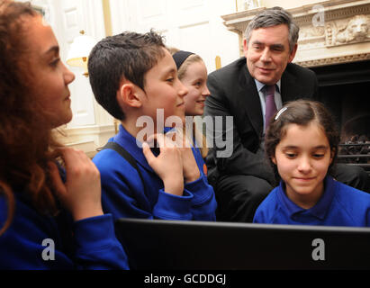 Premierminister Gordon Brown betrachtet einen Computer in der Downing Street 10, London, mit Schulkindern der Anson Primary School in Cricklewood, Nord-London, wo er einen Fortschrittsbericht darüber gab, wie die Regierung versucht, Kinder vor dem Internet zu schützen. Stockfoto