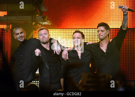 . Ronan Keating wird auf der Bühne von den Mitgliedern von Boyzone während einer Solo-Performance in der Royal Albert Hall, London, begleitet. Stockfoto