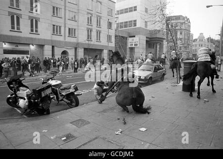 Ein Polizist fällt von seinem Pferd inmitten der Szenen der Unruhen, nachdem eine Anti-Umfrage-Steuer-Demonstration in eine pitchige Schlacht um Trafalgar Square ausbrach. Stockfoto