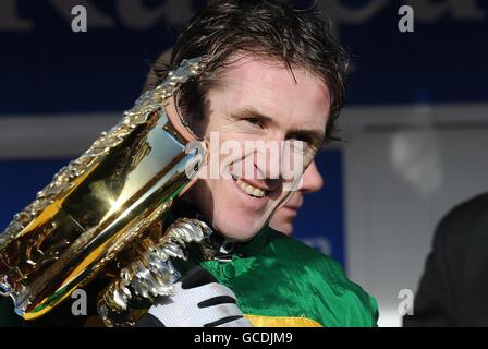 Pferderennen - 2010 Cheltenham Festival - Tag 1. Der Jockey Tony McCoy feiert die Trophäe nach dem Gewinn der „Smurfit Kappa Champion Hurdle Challenge Trophy“ auf Binocular Stockfoto