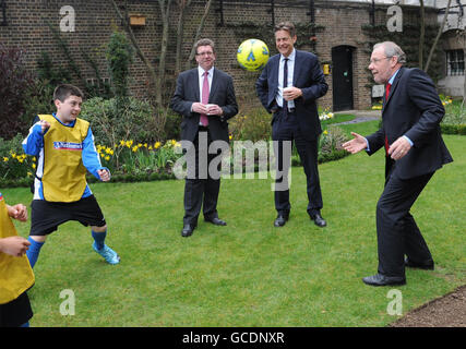 ERNEUTE ÜBERTRAGUNG ZUR ÄNDERUNG DER SCHREIBWEISE VON GERRY SUTCLIFFE. 2018 WM-Bid-Botschafter Richard Caborn MP wirft einen Fußball im Garten der Downing Street 10, London, mit Sportminister Gerry Sutcliffe (links) und Kulturminister Ben Bradshaw, Dort unterzeichneten sie und Premierminister Gordon Brown ein riesiges England-Trikot, um ihre Unterstützung für die englische WM-Mannschaft in diesem Jahr zu zeigen. Stockfoto