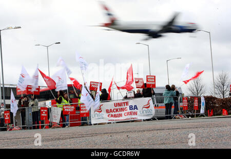 Ein Flugzeug von British Airways fliegt über eine Streiklinie in der Nähe von Hatton Cross, während BA-Kabinenpersonal ihre Streikaktion fortsetzt. Stockfoto