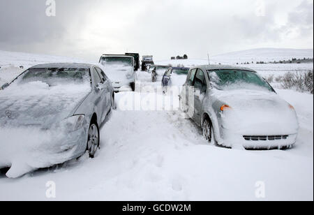 Lastwagen und Autos stecken in Schneeverwehungen auf dem Glenshane Pass bei Londonderry fest, nachdem starker Schnee und Winde über Nacht Chaos in Teilen von Nordirland verursacht haben. Stockfoto