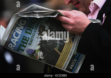 Pferderennen - 2010 Cheltenham Festival - Tag Vier. Ein Rennfahrer liest die Racing Post während des Totesport Cheltenham Gold Cup Day Stockfoto