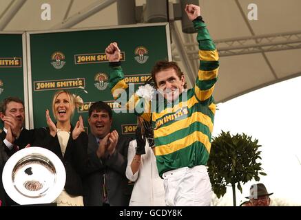 Tony McCoy feiert nach dem Gewinn des John Smith's Grand National auf Don't Push IT auf der Aintree Racecourse, Liverpool. Stockfoto