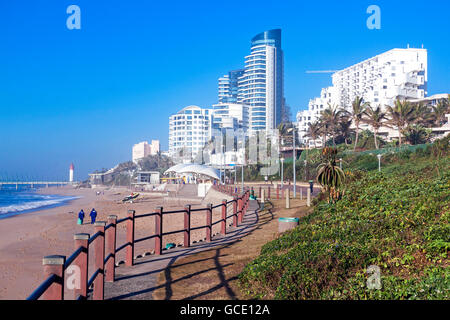 Städtische Arbeiter am frühen Morgen Strand neben dem Dünenvegetation und Gewerbe- und Wohnimmobilien-komplexe Stockfoto