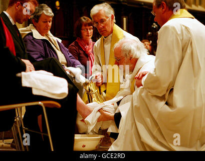 Der Erzbischof von Canterbury, Dr. Rowan Williams (in der Mitte knieend), führt die Gründonnerstags-Fußwaschung in Begleitung von Hochwürden Robert Willis, (oben) Dekan der Kathedrale von Canterbury, in Canterbury, Kent, durch. Stockfoto