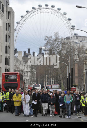 Ein Mitglied der Passage of Westminster Cathedral trägt das Holzkreuz während der traditionellen Karfreitagsprozession, während es entlang der Victoria Street in Richtung Westminster Cathedral im Zentrum von London geht. Stockfoto