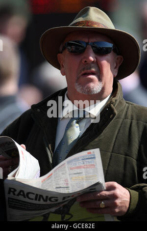 Pferderennen - Coral Scottish Grand National Festival - Erster Tag - Ayr Racecourse. Ein Rennfahrer liest die Racing Post während des Coral Scottish Grand National Festivals auf der Ayr Racecourse, Ayr. Stockfoto