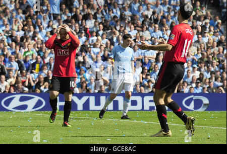 Wayne Rooney von Manchester United (links) und Ryan Giggs (rechts) geben beim Spiel der Barclays Premier League im City of Manchester Stadium in Manchester eine verpasste Chance. Stockfoto