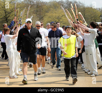 Sir Ian Botham im Hyde Park, London, nachdem er die letzte Etappe seines 10-tägigen landesweiten Forget-Me-Not Walk in Aid of Leukemia Research absolviert hatte, wo er seinen Enkel James, 12, und den Schauspieler Hugh Grant (hinten Mitte) unter einem Ehrenbogen von verletzten Schülern der Emmanuel School in Battersea begleitet wurde. Stockfoto