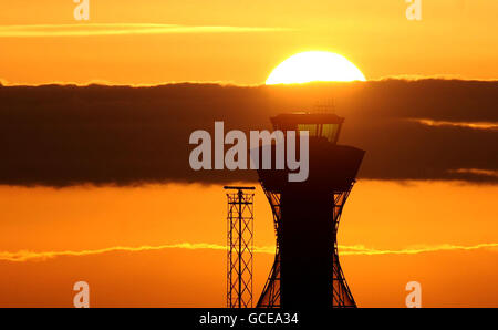 Vulkanische Asche verursacht Reiseunterbrechungen. Die Sonne geht über dem Kontrollturm am Flughafen Newcastle unter. Stockfoto