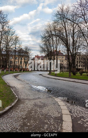 Pflasterung Straße schlängelt sich durch die Altstadt in der Nähe des Parks in der frühen Herbstmorgen Stockfoto