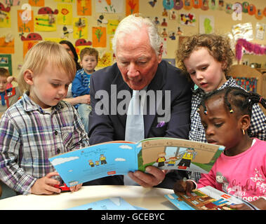 Broadcaster und CEO der Road Safety Authority Gay Byrne liest aus dem Vorschulpaket an (von links nach rechts) Jamie, Hayden und Kaberat, die alle von der Sophia Housing Association creche 'Le Cheile' bei der Einführung von 'Simon and Friends' The RSA's neuem Ressourcenpaket für Vorschulen in Dublin sind. Stockfoto