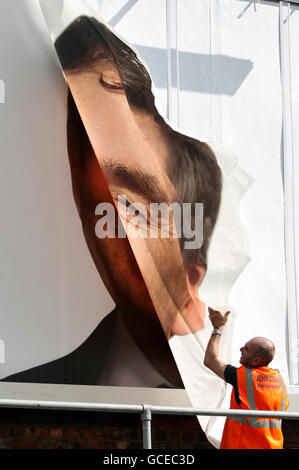 Ein Arbeiter entfernt eine entstellte Plakatwand der Konservativen Partei, auf der das Gesicht von Premierminister Gordon Brown in der Gegend von Old Trafford in Manchester zu sehen ist. Stockfoto